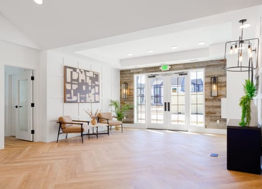 a living room with white walls and wood floors and glass doors