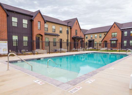 a swimming pool with apartments in the background