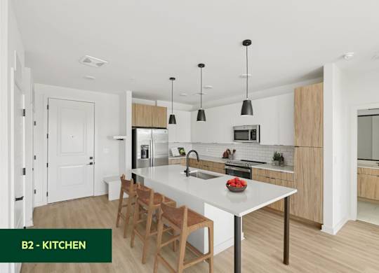 A modern kitchen with a white countertop and wooden chairs.