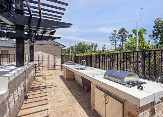 A patio with a grill and a table.