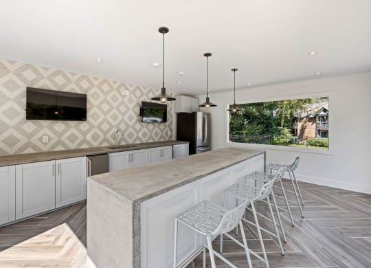 a large kitchen with a long counter and bar stools at View at Lake Lynn, Raleigh, NC