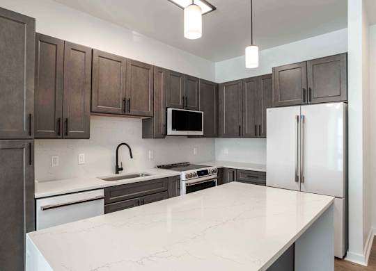 a kitchen with a white counter top and a refrigerator