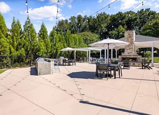 a patio with tables and umbrellas and a fire pit at View at Lake Lynn, Raleigh North Carolina