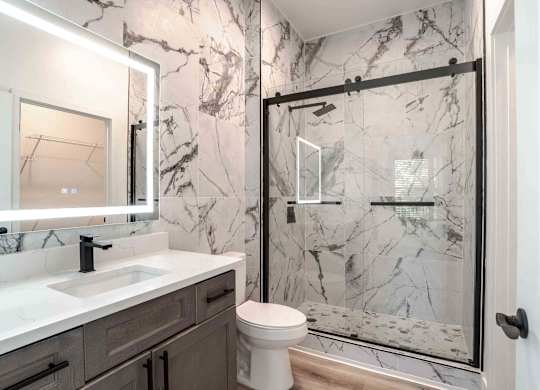 a bathroom with a shower and a sink and a toilet