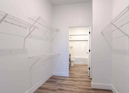 an oversized closet with white walls and wood floors