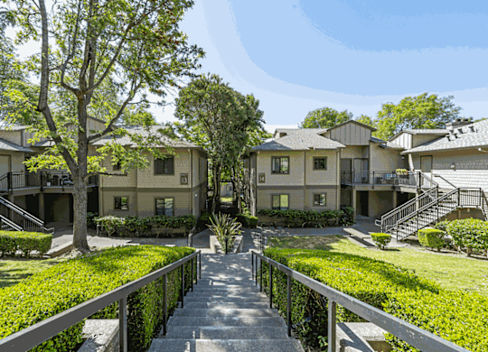 the view of an apartment complex with stairs and lawns