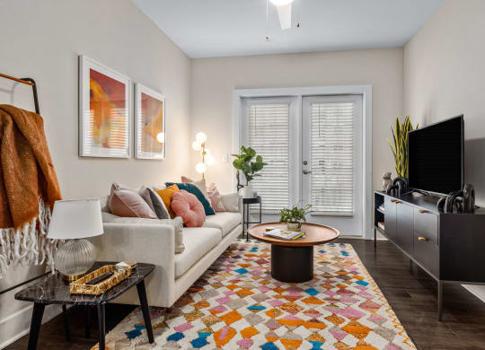 shot of furnished model unit living room with doors leading out to patio