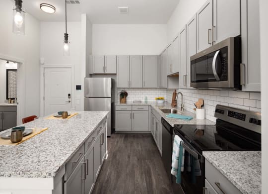 a kitchen with marble counter tops and white cabinets