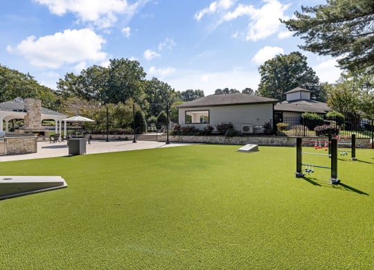 a putting green with a house in the background at View at Lake Lynn, Raleigh