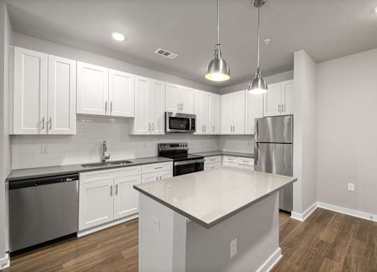 A modern kitchen with white cabinets and stainless steel appliances.