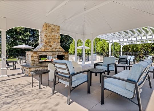 the outdoor patio has a fireplace and tables with chairs at View at Lake Lynn, Raleigh, NC 27613