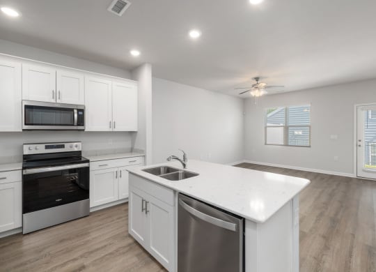 a renovated kitchen with white cabinets and stainless steel appliances