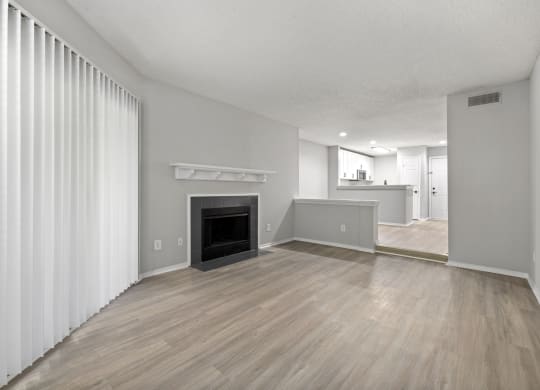 a living room with a fireplace and wood flooring