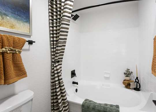 A bathroom with a white tub and a shower curtain.