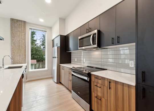 A modern kitchen with wooden cabinets and black appliances. at Ion Town Center, Shorelin