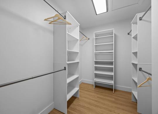 A walk in closet with shelves and hangers.