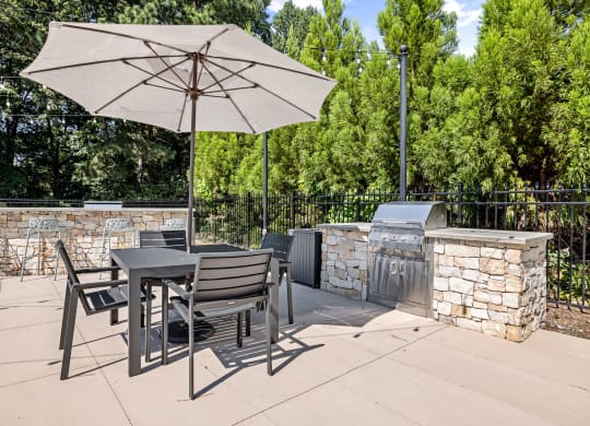 a patio with a table and chairs and an umbrella at View at Lake Lynn, North Carolina, 27613