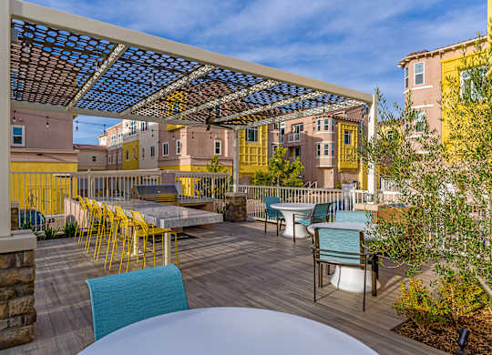 A patio with a table and chairs under a roof.