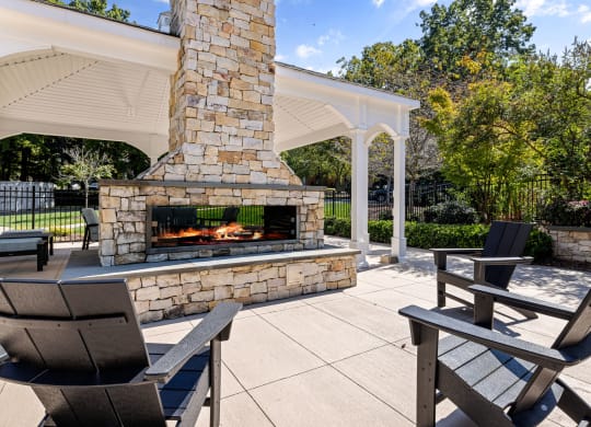 the outdoor patio has a stone fireplace and seating areas at View at Lake Lynn, Raleigh North Carolina