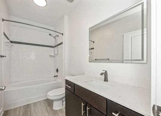 A white bathroom with a toilet, sink, and shower.