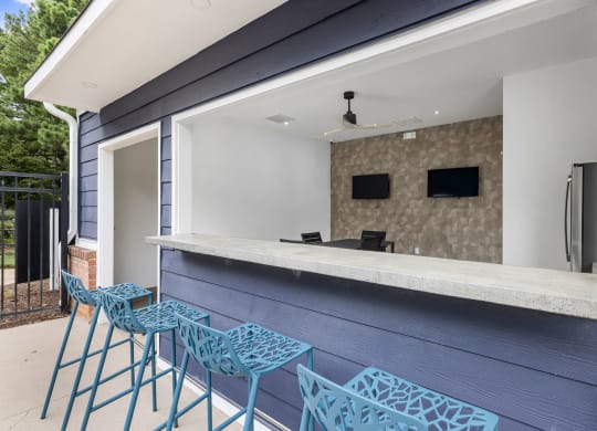 a bar with blue bar stools in front of a house at Mariners Crossing, North Carolina, 27612
