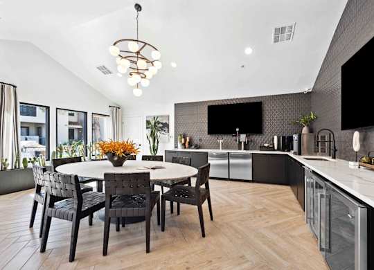 A modern kitchen with a dining table and chairs.
