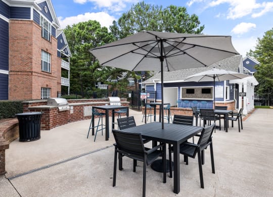 a patio with a table and chairs with umbrellas at Mariners Crossing, Raleigh North Carolina