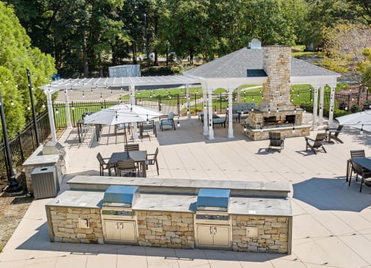 a patio with a grill and tables with umbrellas at View at Lake Lynn, Raleigh, 27613