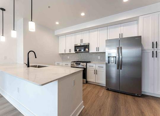 kitchen at The Vive Collection, featuring white cabinets and a kitchen island.