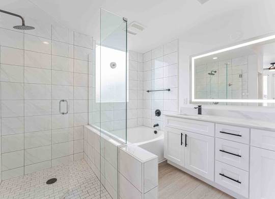 a white bathroom with a shower and a sink