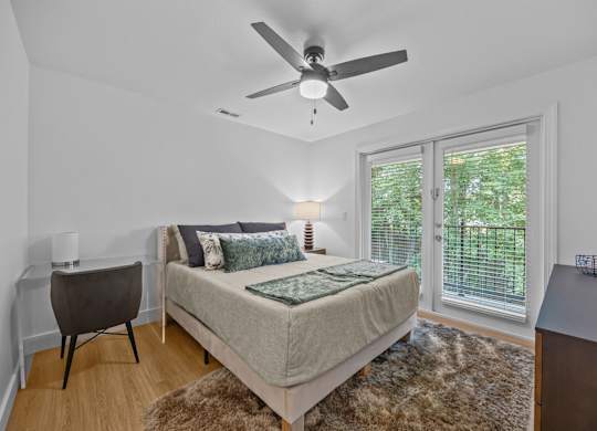 A bedroom with a bed, chair, and window.