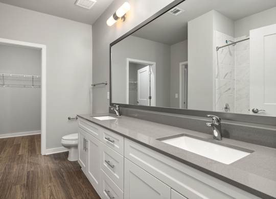 A bathroom with a white sink and a large mirror.
