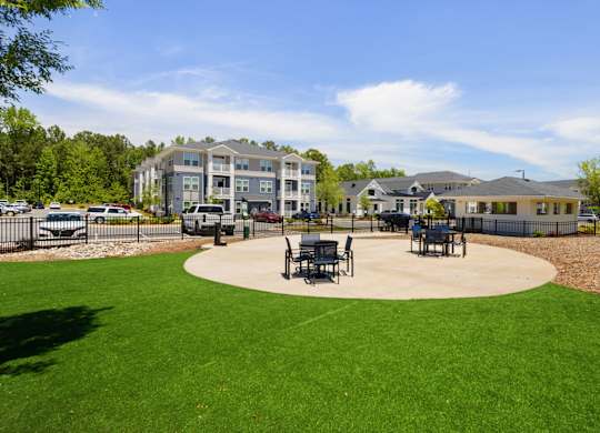 A large grassy area with a circular concrete center and benches.