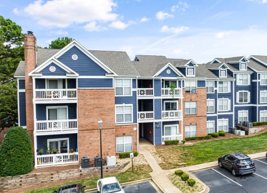 an apartment building with cars parked in a parking lot at Mariners Crossing, Raleigh North Carolina