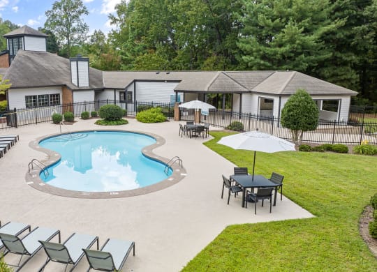 an outdoor pool with chairs and a house in the background at View at Lake Lynn, North Carolina, 27613
