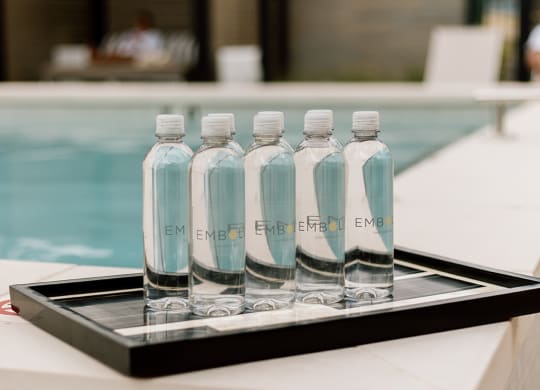 a tray of water bottles sits on the edge of a pool  at Embold, Lehi, UT