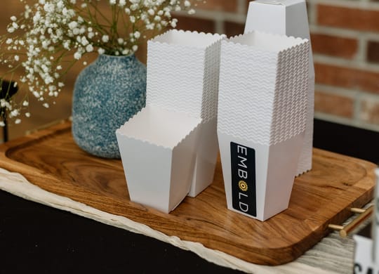a pair of white boxes on a wooden tray next to a blue vase with white flowers  at Embold, Utah, 84043
