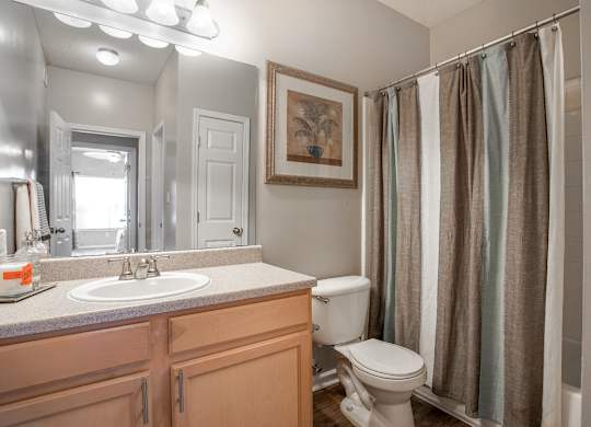 A bathroom with a toilet, sink, and shower.