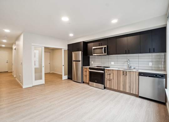 A kitchen with a refrigerator, oven, and microwave. at Ion Town Center, 98133