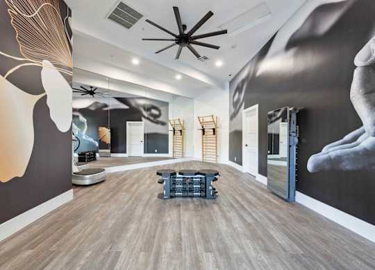A room with a large mural on the wall and a ceiling fan.