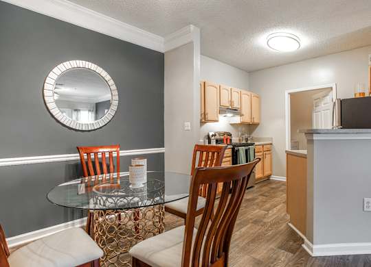 A kitchen and a dining area with a table and chairs at Peachtree Landing apartments for rent 30213.