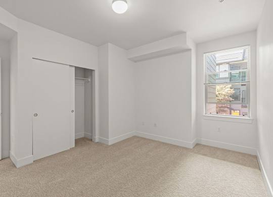 Empty bedroom with walk-in closet and carpet at Six Oaks Apartments, Washington