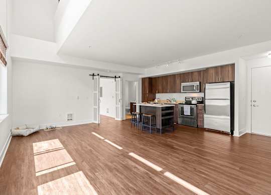 Spacious living room with kitchen island and modern finishes at Six Oaks Apartments, Bothell, WA