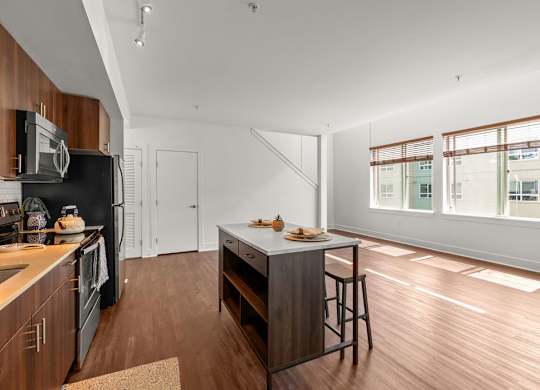 Kitchen with island and open living space at Six Oaks Apartments, Bothell, WA