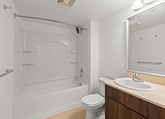 Bathroom with white tub shower and wood vanity at Six Oaks Apartments, Bothell, WA