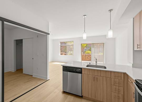 Kitchen with wood cabinets and sliding door entry at Six Oaks Apartments, Bothell, WA 98011
