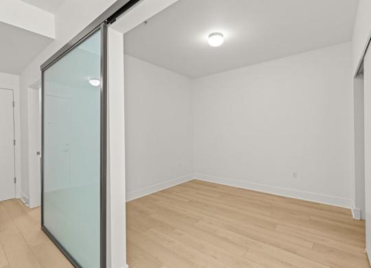 Empty room with frosted glass sliding partition at Six Oaks Apartments, Bothell, WA