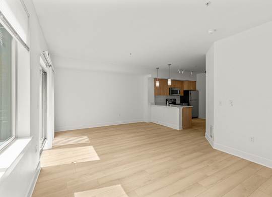 Open living room with kitchen and light wood floors at Six Oaks Apartments, Washington, 98011