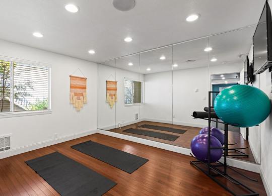 Home yoga studio with mirrored wall and exercise balls at Scout Apartments, Washington, 98034