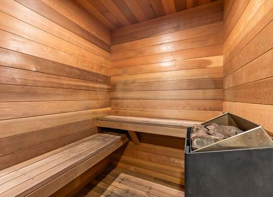 Sauna room with wooden benches and heater at Scout Apartments, Kirkland, WA 98034